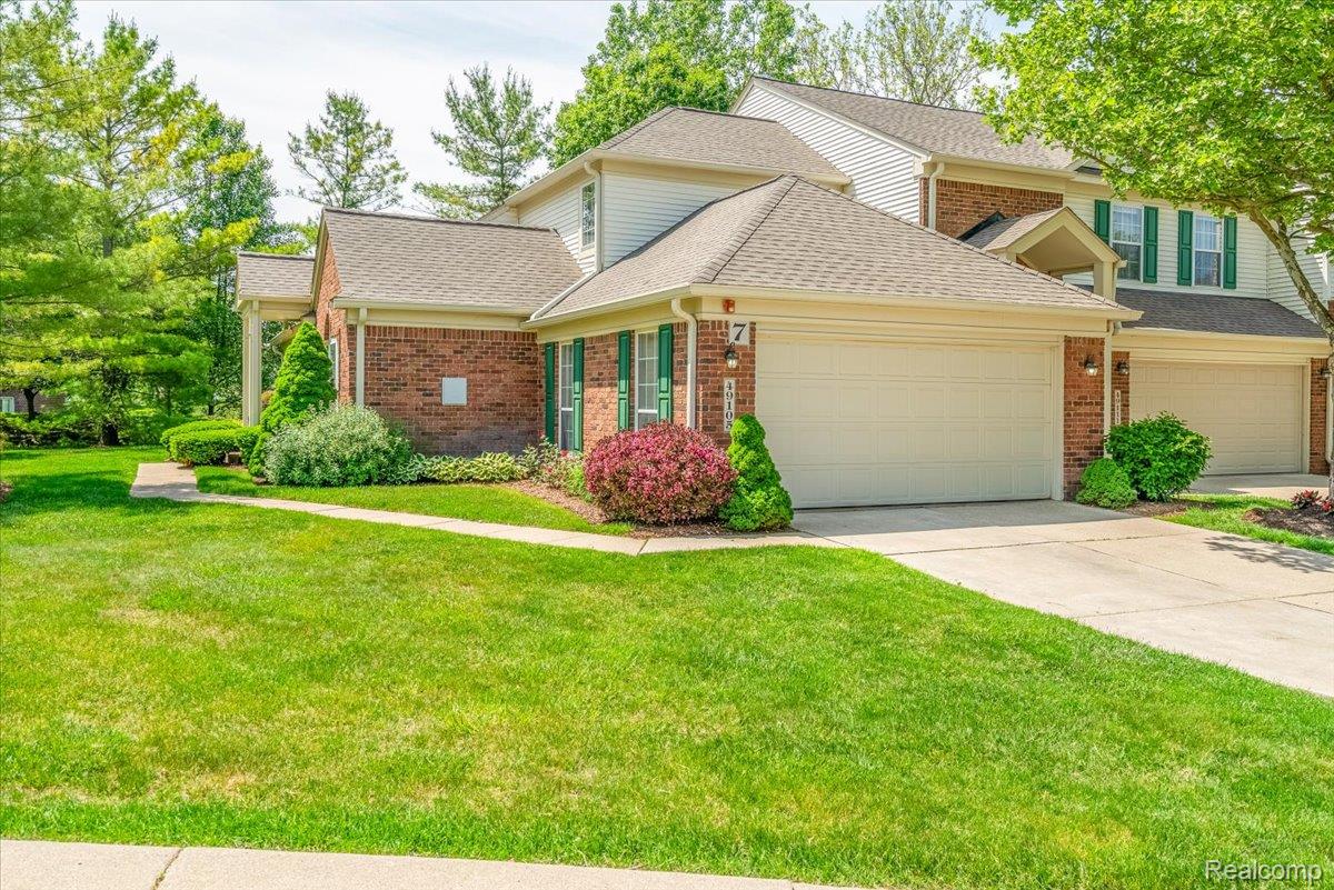 49105 Hawksburry Road Canton, MI 48188 - Photo 2 of 51 Exterior featuring brick and siding construction, covered entry, attached garage, green shutters, and established landscaping