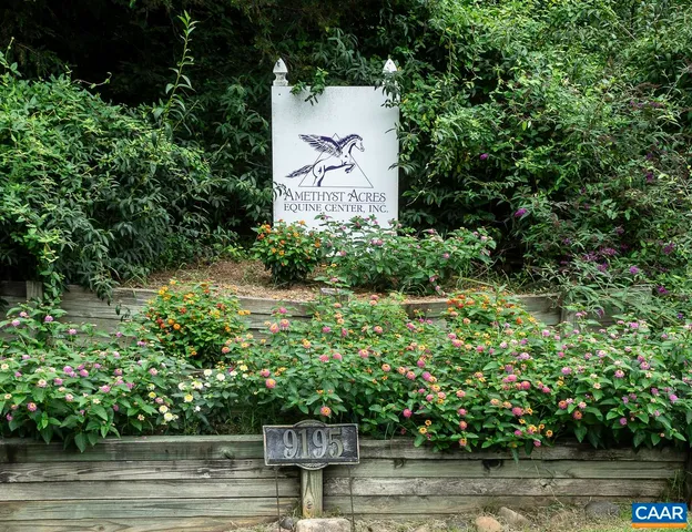an aerial view of a house with a yard lake and outdoor seating