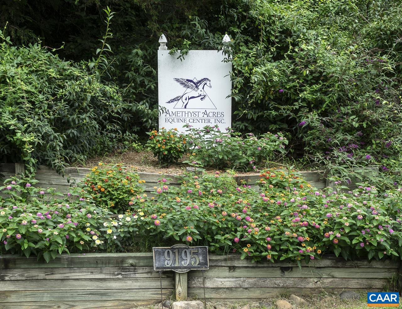 an aerial view of a house with a yard lake and outdoor seating
