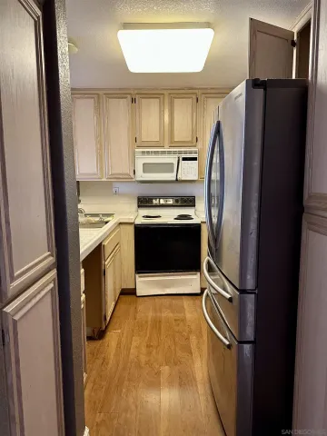 a kitchen with granite countertop a refrigerator and a sink
