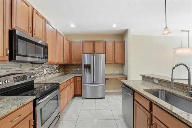 a kitchen with stainless steel appliances granite countertop a sink stove and refrigerator