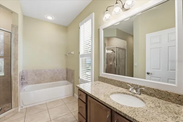 a bathroom with a granite countertop tub sink and mirror