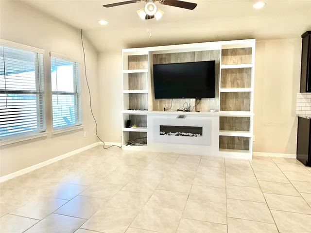 a view of living room with flat screen tv and windows