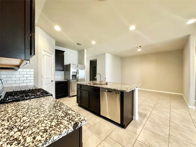a kitchen with stainless steel appliances granite countertop a stove and a sink