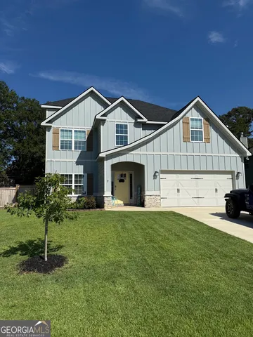 a front view of a house with a garden and yard