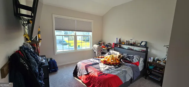 a bed sitting in a bedroom next to a window