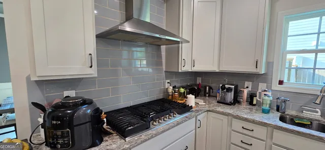 a kitchen with granite countertop white cabinets and white appliances