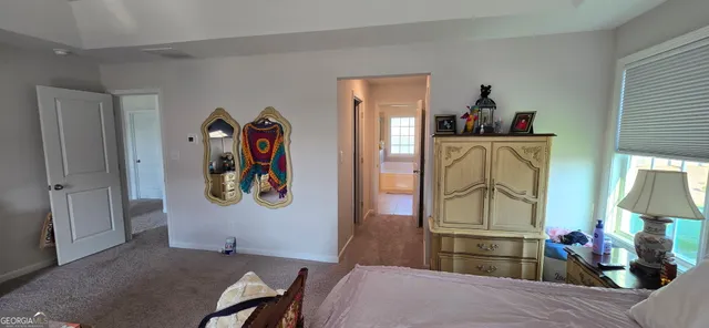 a bedroom with a bed and dresser with mirror