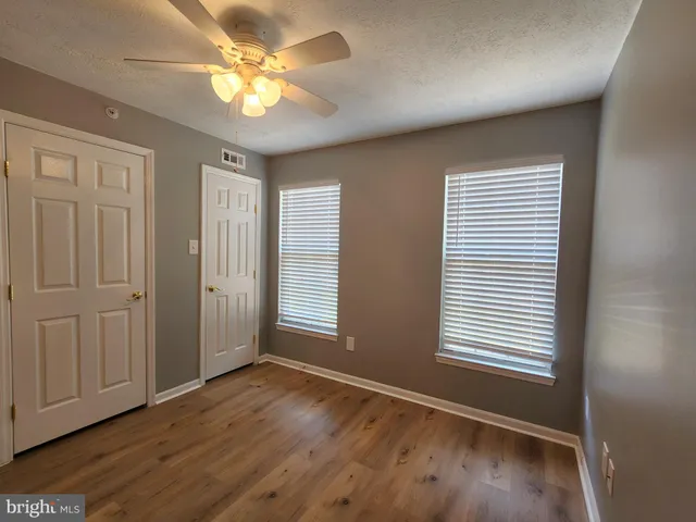 a view of empty room with wooden floor
