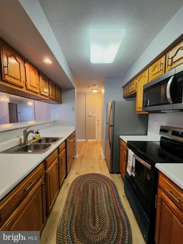 a kitchen with stainless steel appliances a stove microwave and refrigerator