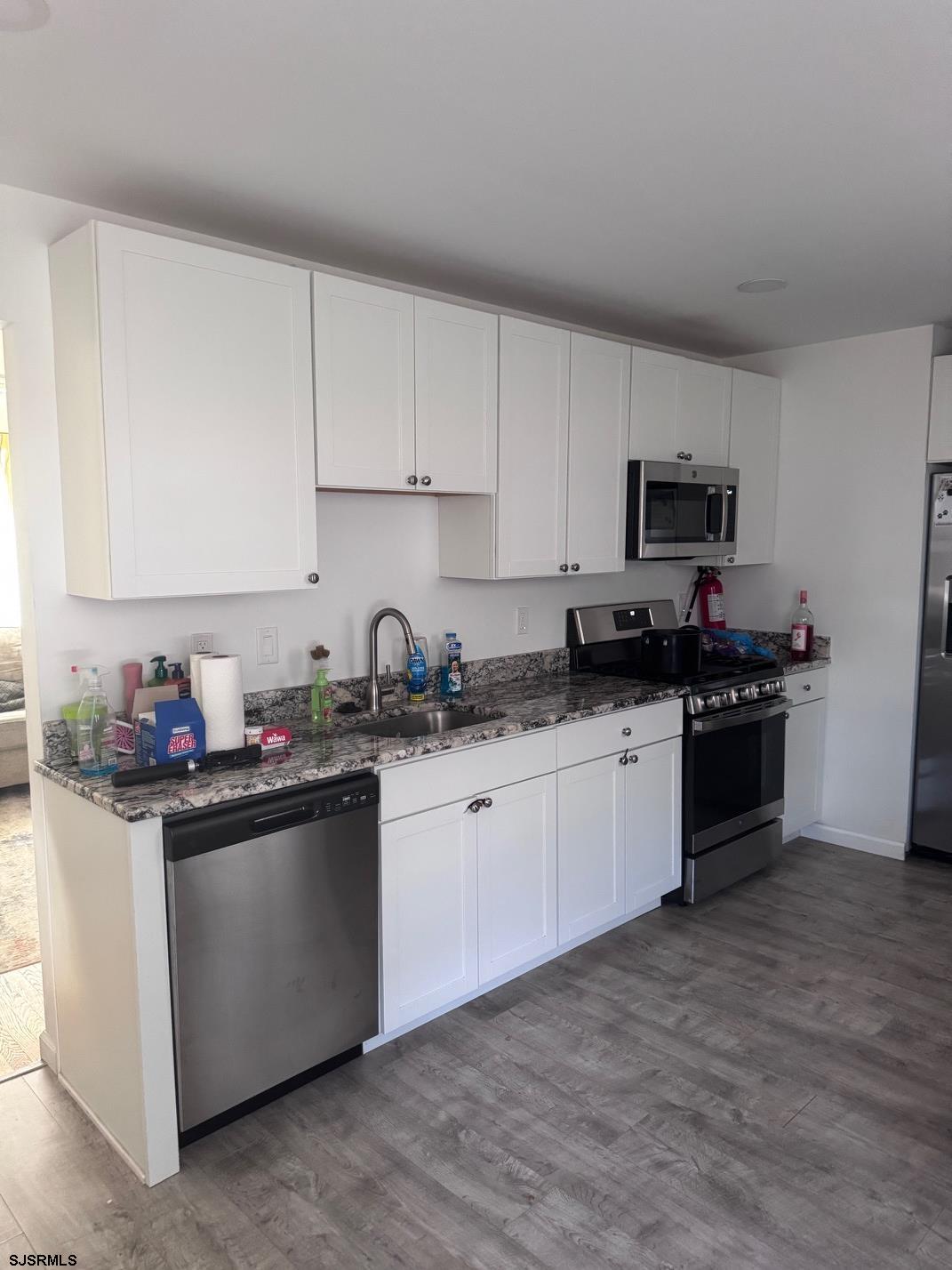 12 Colwick Drive Somers Point, NJ 08244 - Photo 4 of 17 a kitchen with stainless steel appliances granite countertop a stove top oven a sink a refrigerator and white cabinets