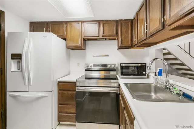 a kitchen with stainless steel appliances granite countertop a sink stove and refrigerator