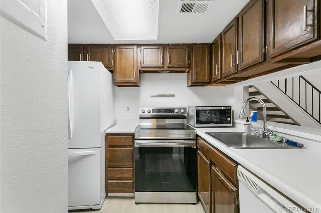 a kitchen with stainless steel appliances granite countertop a refrigerator stove a sink and dishwasher