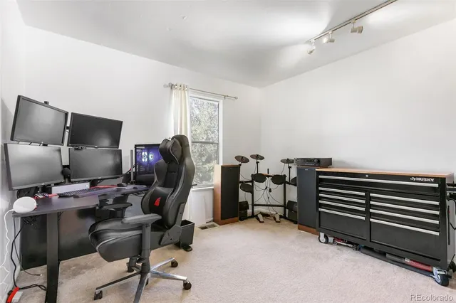 a view of a workspace with furniture and a window