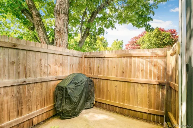 a roof deck with wooden fence and trees