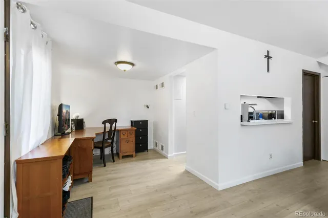 a view of a workspace with furniture and a window