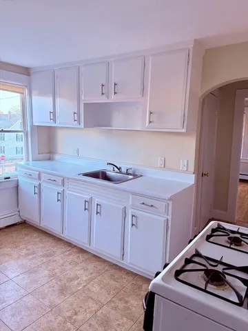 a kitchen with granite countertop white cabinets and white appliances