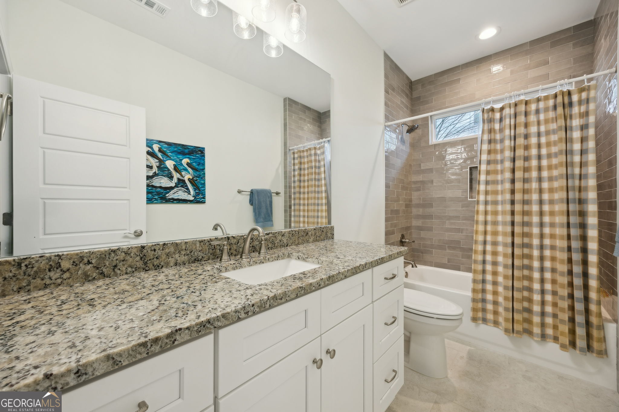 212 Placid Road St. Marys, GA 31558 - Photo 28 of 75 a bathroom with a granite countertop sink a toilet a mirror and shower