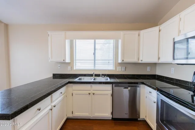 a kitchen with stainless steel appliances granite countertop a sink a refrigerator and a stove