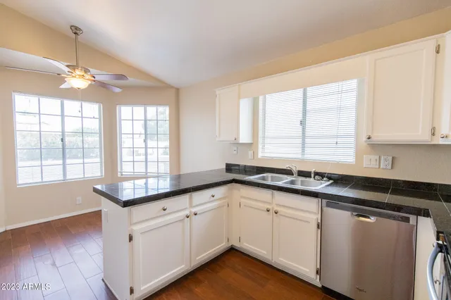 a kitchen with granite countertop white cabinets and white appliances