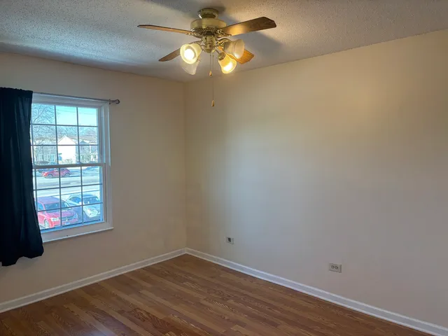 an empty room with a window and a fan