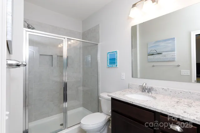 a bathroom with a granite countertop sink toilet and shower