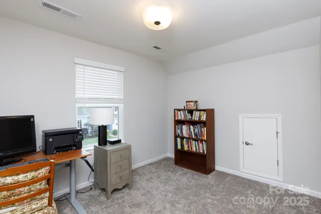 a view of a workspace with furniture and a window