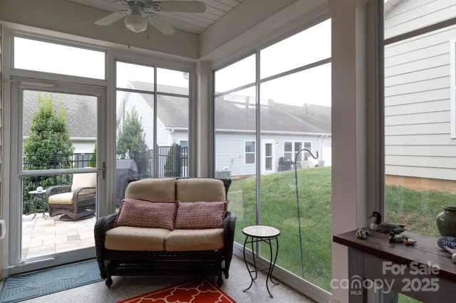 a living room with furniture and a floor to ceiling window