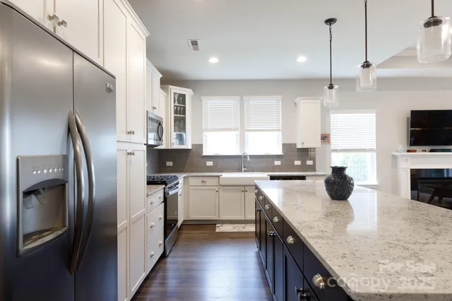a kitchen with stainless steel appliances granite countertop a sink a stove and a refrigerator