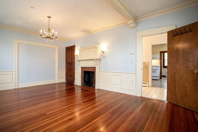 a view of empty room with wooden floor and fireplace