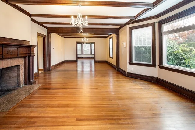 a view of empty room with wooden floor and fireplace
