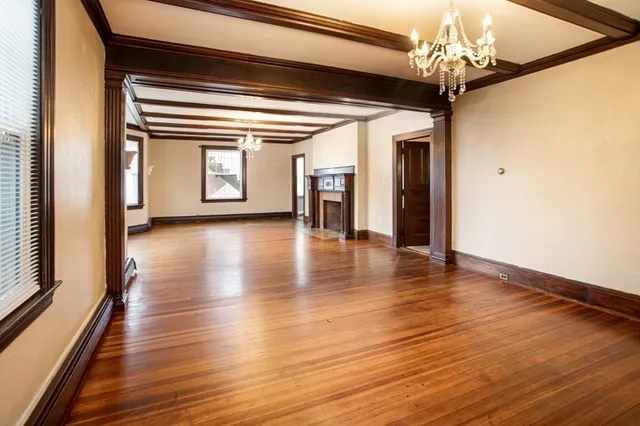 a view of a hallway with wooden floor and a chandelier