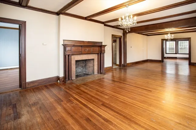 a view of a livingroom with wooden floor a fireplace and window