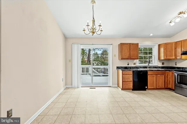 a large kitchen with granite countertop a stove top oven a sink a counter space and cabinets