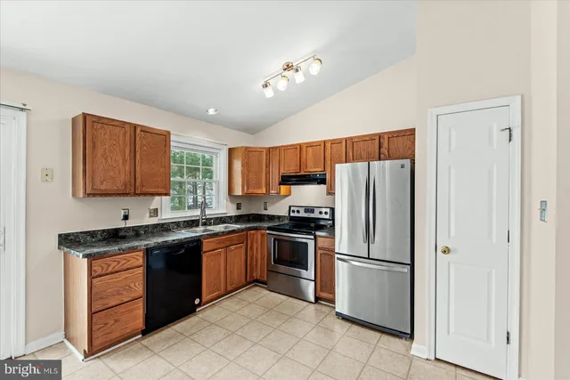 a kitchen with stainless steel appliances granite countertop a refrigerator sink and cabinets