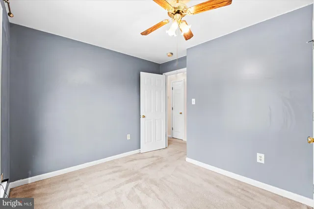 an empty room with a chandelier fan and a chandelier fan