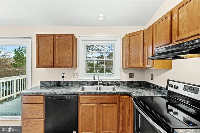 a kitchen with stainless steel appliances granite countertop a sink stove and cabinets