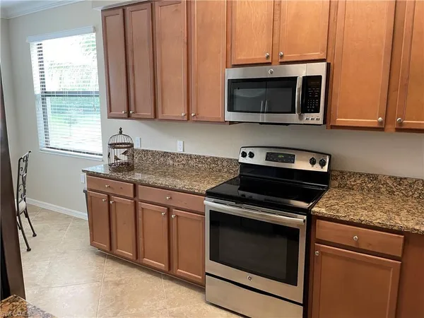 a kitchen with granite countertop a stove and a microwave