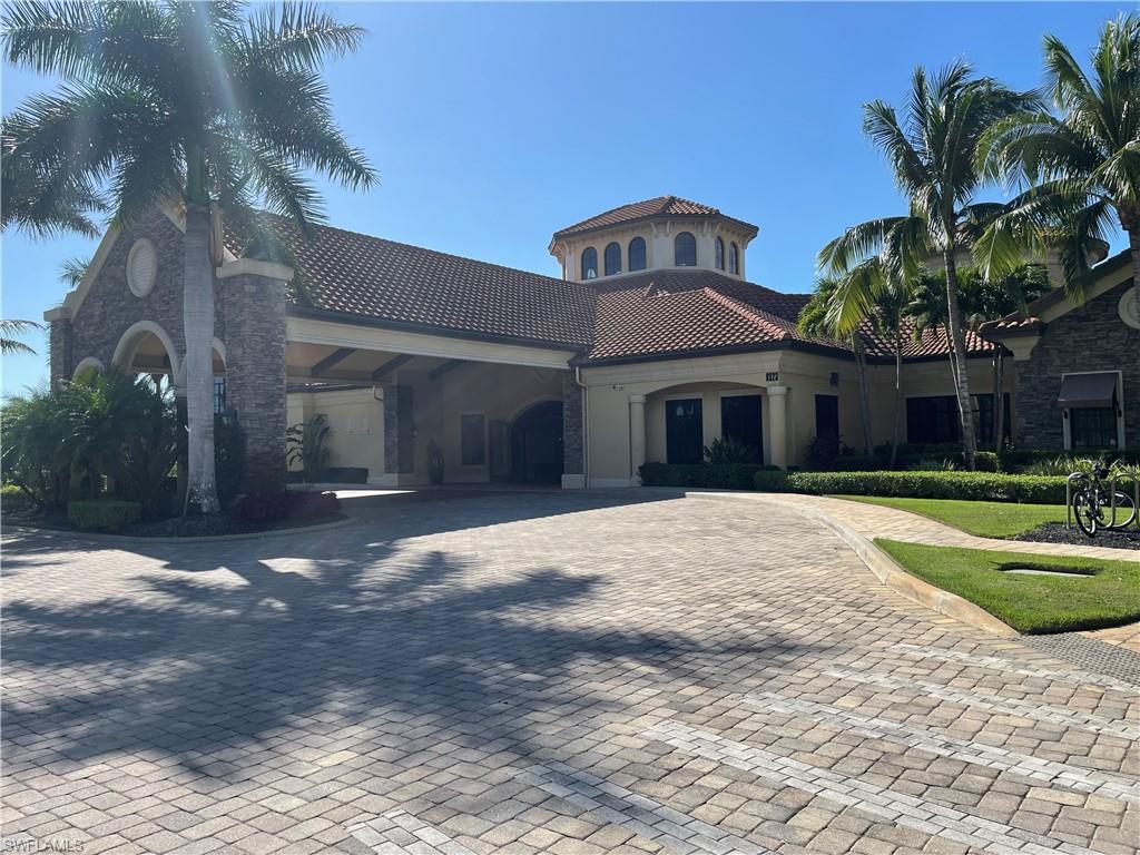 9727 Acqua Court, Unit 421 Naples, FL 34113 - Photo 18 of 26 a front view of a house with a yard and garage