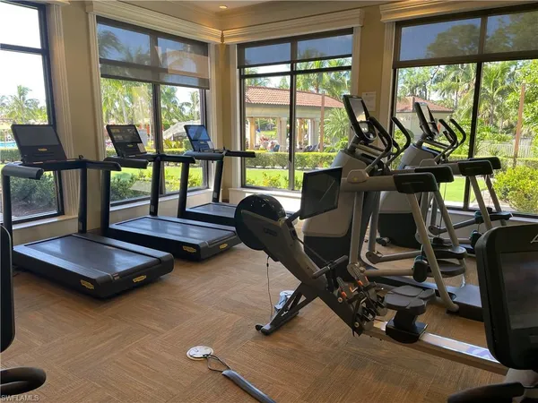 a room with gym equipment and large windows
