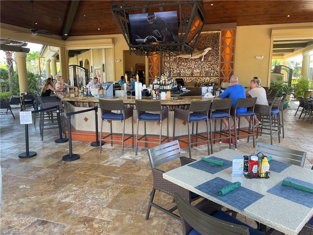 9727 Acqua Court, Unit 421 Naples, FL 34113 - Photo 24 of 26 a view of a dining tables and chairs in a patio