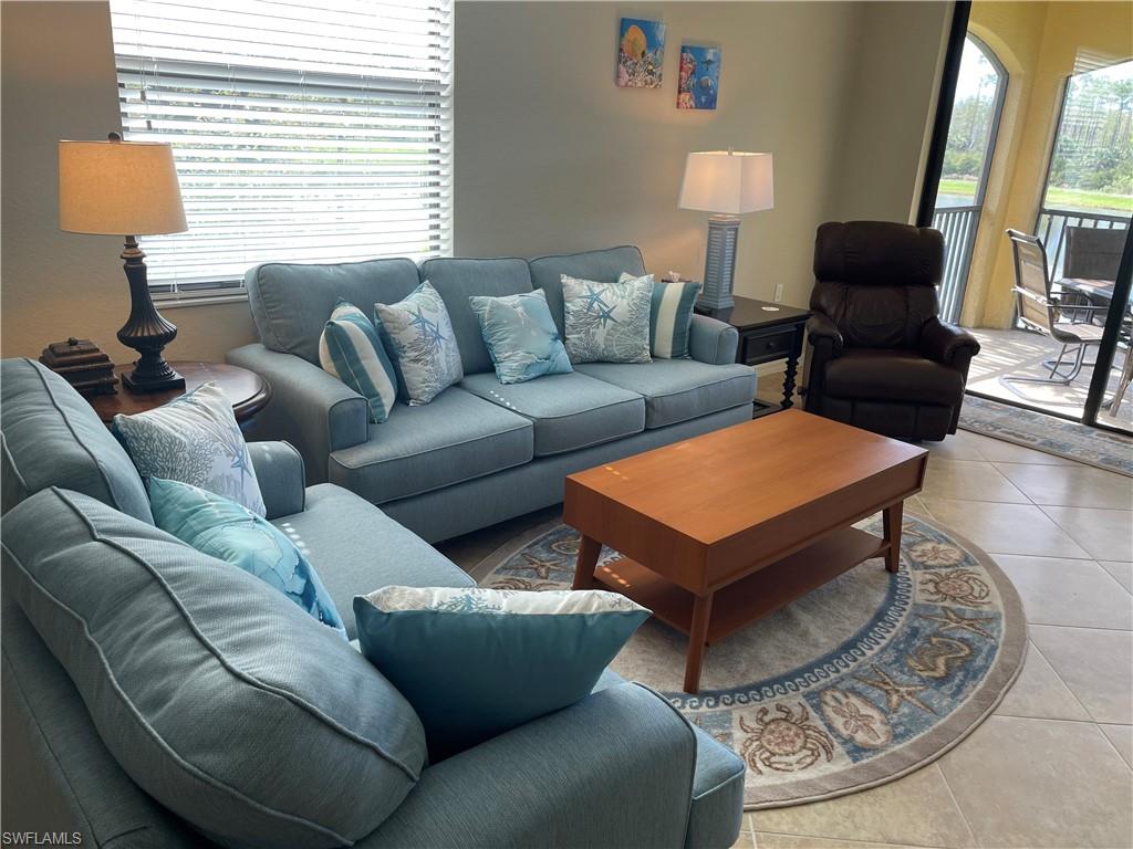 9727 Acqua Court, Unit 421 Naples, FL 34113 - Photo 5 of 26 a living room with furniture and a lamp