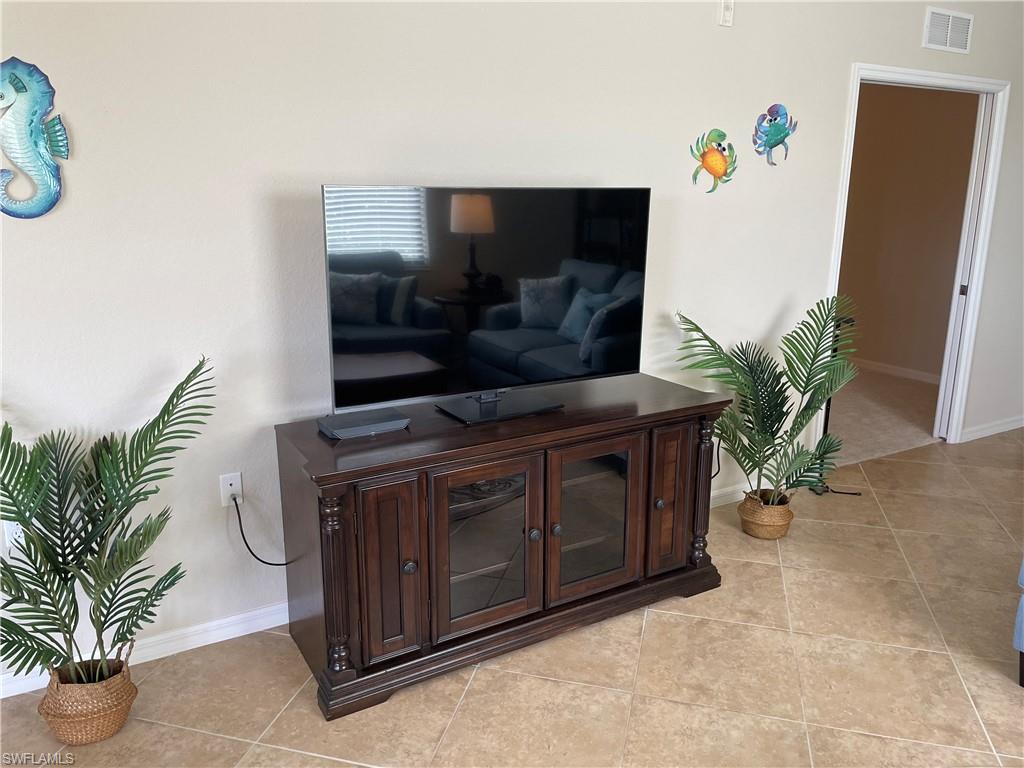 9727 Acqua Court, Unit 421 Naples, FL 34113 - Photo 7 of 26 a living room with furniture and a potted plant