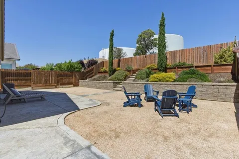 a view of a chairs and table in the back yard of the house