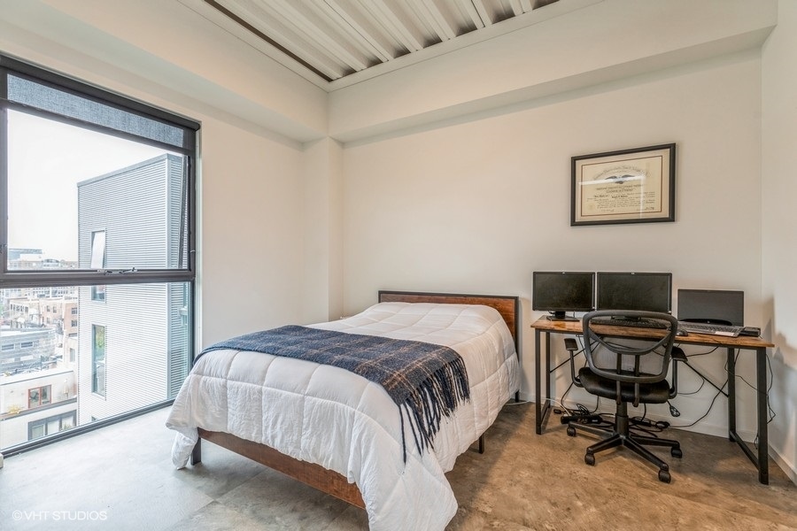 1220 West Jackson Boulevard, Unit 814 Chicago, IL 60607 - Photo 6 of 10 a bed sitting in a bedroom next to a window