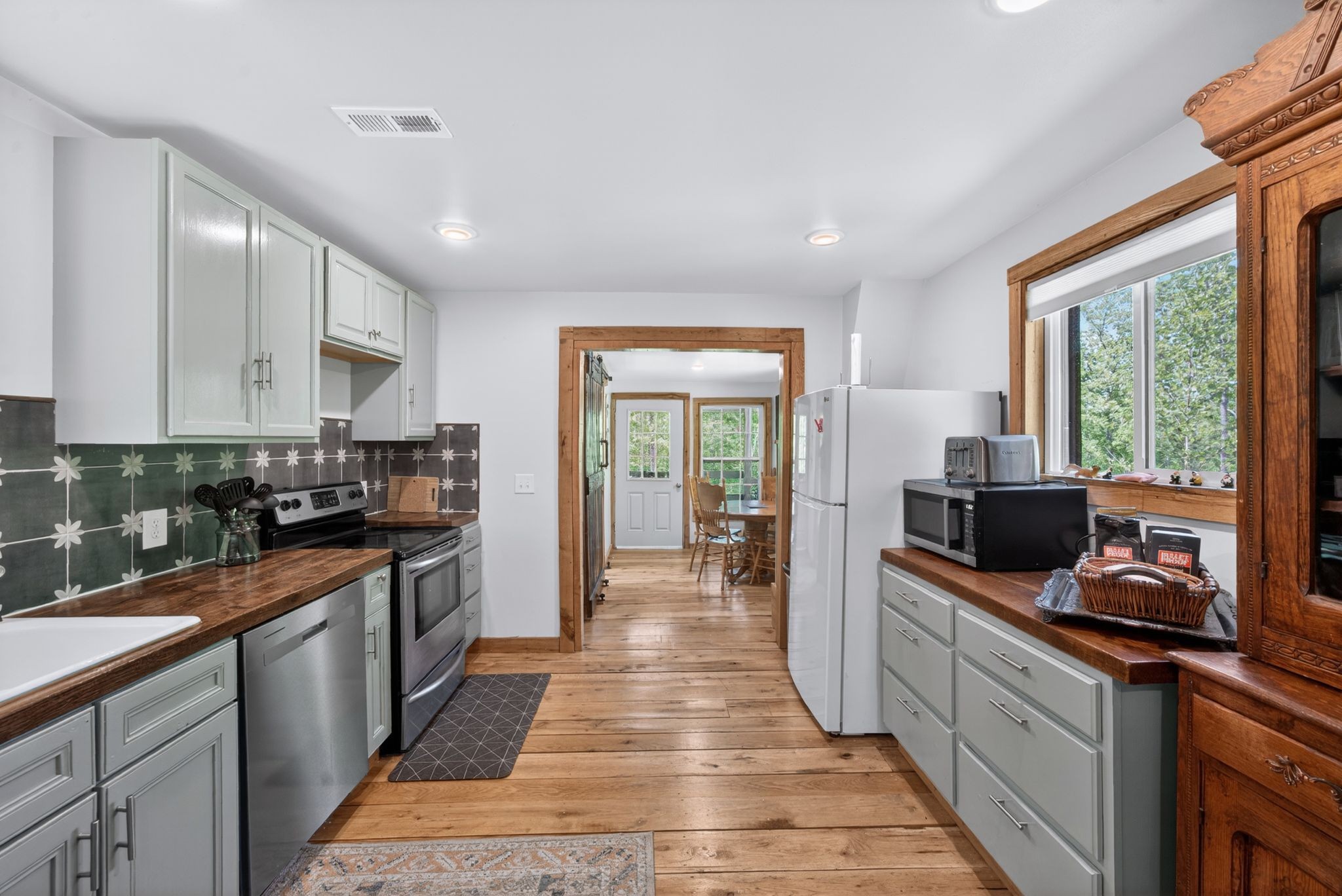 1030 Johnson Hollow Road McEwen, TN 37101 - Photo 34 of 78 a kitchen with stainless steel appliances granite countertop a stove top oven a sink dishwasher a refrigerator and white cabinets with wooden floor