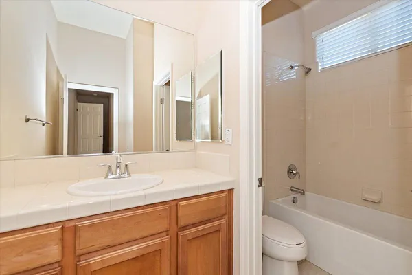 a bathroom with a granite countertop sink a toilet and a bathtub