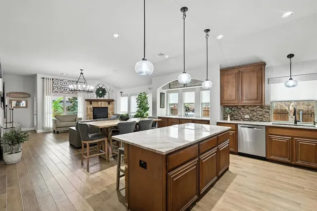 a kitchen with a stove center island a dining table and chairs