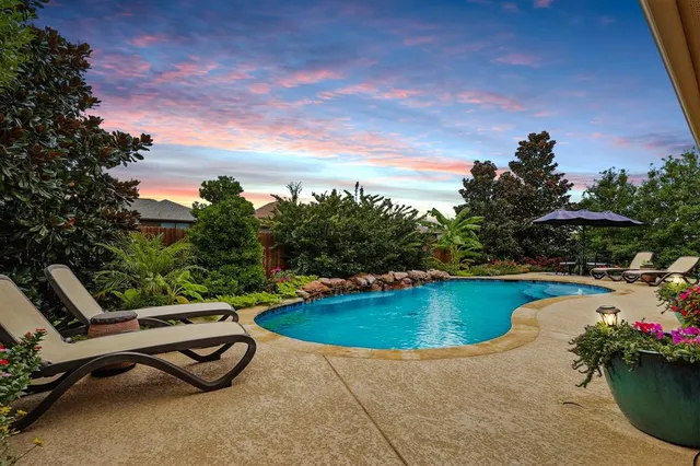 a kitchen with stainless steel appliances granite countertop a stove a refrigerator a kitchen island a table and chairs