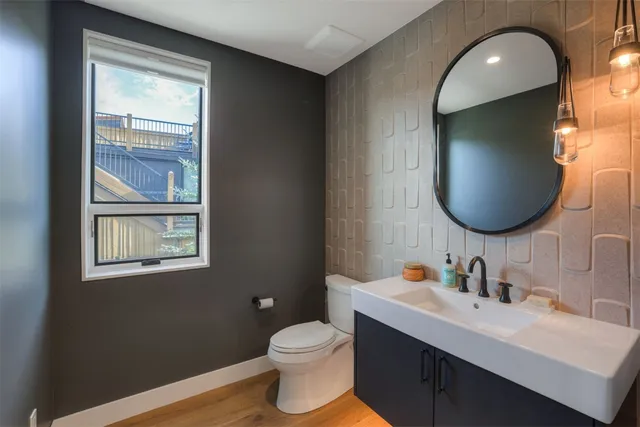 a bathroom with a toilet sink vanity granite and a mirror